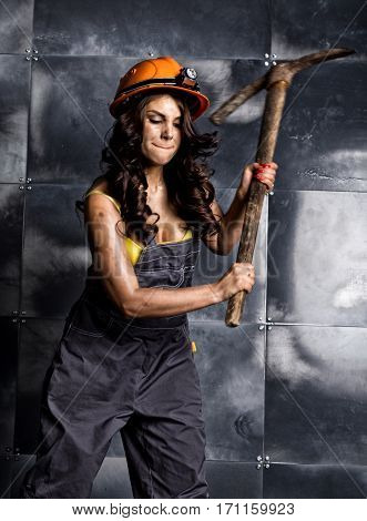 sexy female miner worker with pickaxe, in coveralls over his naked body.