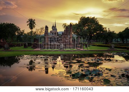 Buddha Statue at Wat Mahathat in Sukhothai Historical Park and water lilly in the poolThailand