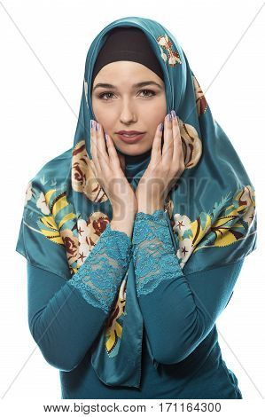 Female wearing a hijab conservative fashion for muslims middle east and eastern european culture. She is isolated on a white background and looking shy