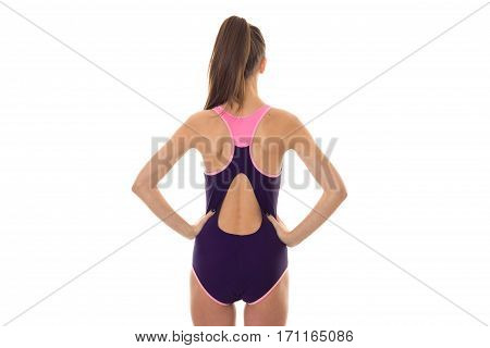 beautiful slim young brunette girl in body swimsuit with sexy round buttocks and hands on her hips from backside isolated on white