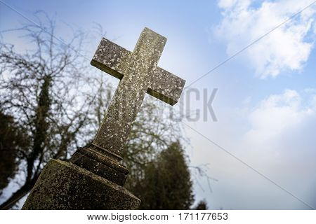 weathered stone cross or gravestone against the blue sky memorial day concept for war dead or religious christian symbol for holiday like good friday easter and pentecost also used for halloween
