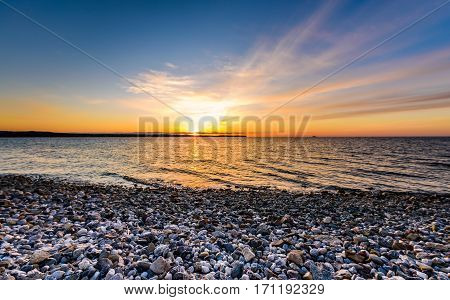 Stones On A Beach With Sunset On The Ocean Sea.
