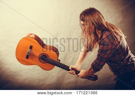 Rock music energy people feelings concept. Mad rock guitarist destroys his guitar.