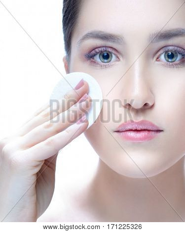 portrait of attractive young caucasian woman brunette isolated on white studio shot  face skin looking at camera hand care cleaning cotton discs makeup nails lips looking at camera beauty spa