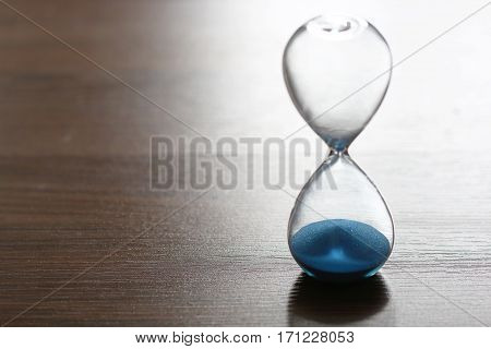 Close up hourglass on wooden floor for time concept