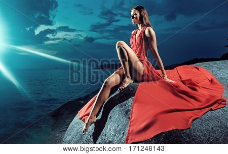 Glamorous brunette in the moon rays at the sea