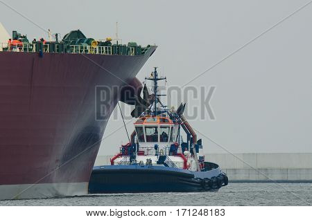 TUG AT GAS CARRIERS - Tug insures large tanker in the harbor