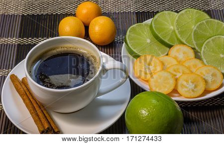 A cup of coffee with cinnamon and lime