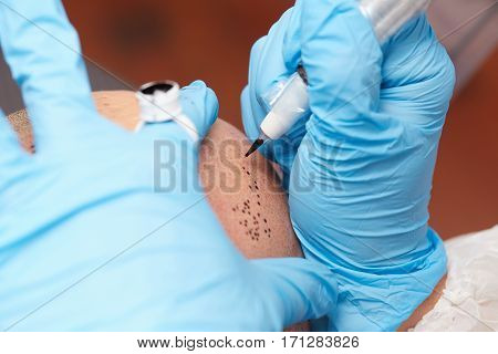 professional tattooist making permanent make up tricopigmentation