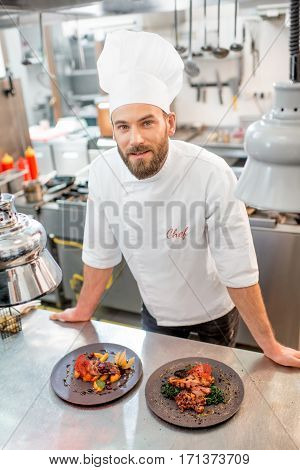 Portrait of chef cook in uniform with prepaired delicious dish at the restaurant kitchen