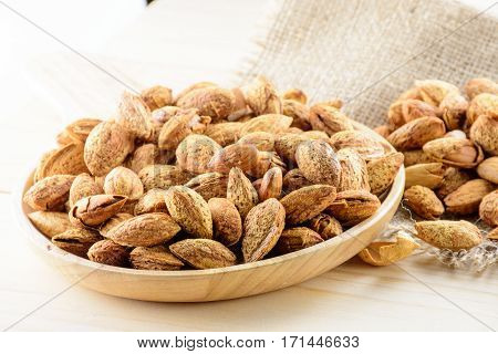Almond nuts in shell baked with butter and salt on wooden