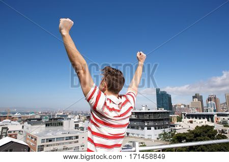 Behind Of Young Man With Arms Raised Outsice