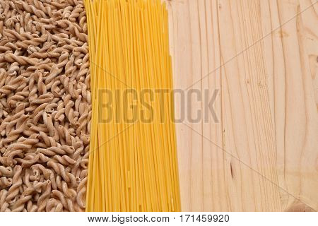 Wholemeal Pasta Fusilli From Organic Grain And Spaghetti From White Flour On A Rustic Wooden Table.