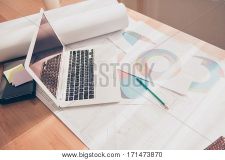 Photo of working place of engineer with blueprint diagramas and laptop