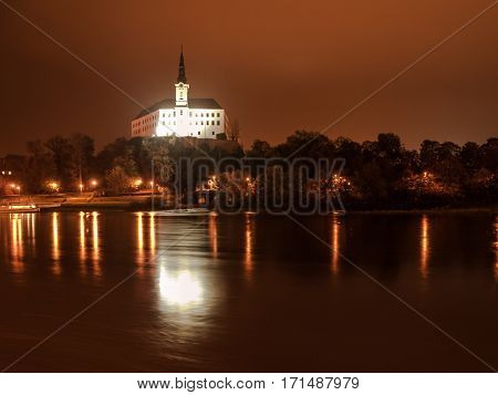 Decin Castle reflected in Elbe River by night, Czech Republic, Europe.