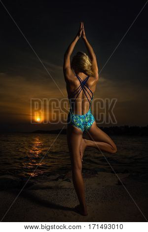 Yoga by woman on the beach near the ocean