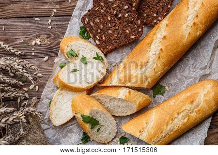 Photo of baguette , bread on table with seeds and herbs
