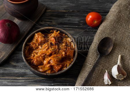 Bigus with sausages in a wooden bowl on a rustic background