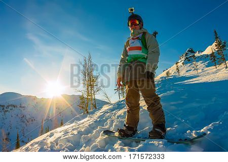 Freeride Snowboarder Stands On Hillside In Light Dawn Sun