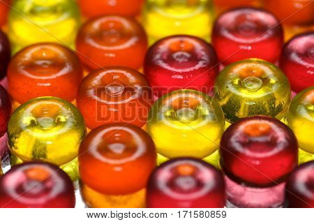 Colorful candy background with yellow orange and pink sweetmeats candies. Dolce vita. Lollipop background closeup. Sweet candy background. Lollipops and candies.