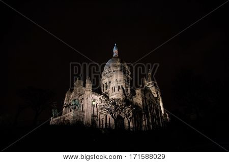 Basilica of  Sacre Coeur on Montmartre hill by night, Paris, France.