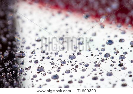 Abstract grey background with gradient color water drops on glass with reflection, bockeh, macro