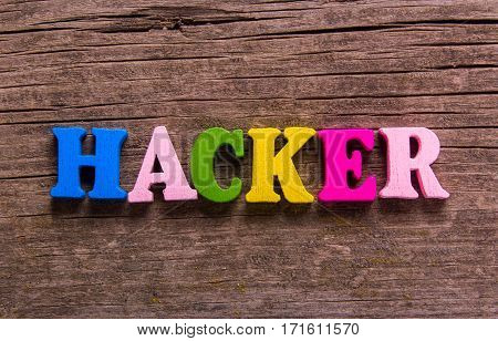 hacker word made from colored wooden letters on an old table. Concept
