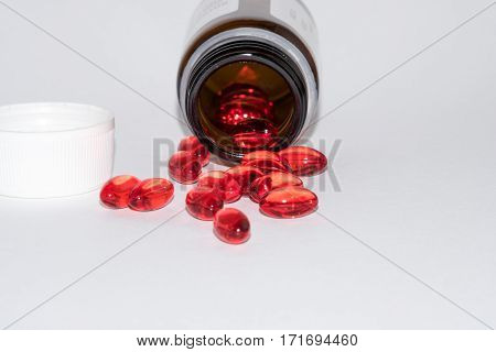 Tabs Vitamins omega 3 Medications tablets and capsules in a beaker. Medications tablets suppository bottles capsules and thermometer on wooden table