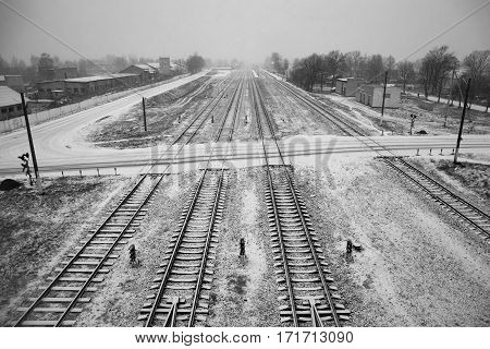 Belarus - November 2016 Long railroad tracks in the snow winter on the railroad farm sheds endless path top view view from the bridgerailway traffic black and white imageroad sign