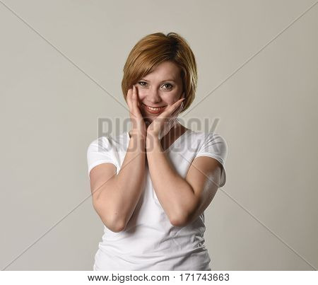 young attractive and beautiful red hair woman smiling happy and cheerful in friendly joyful face expression gesturing and having fun isolated on grey background in happiness emotion concept