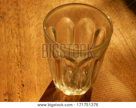 Glass of dirty water that sunlight shines quaint evening.