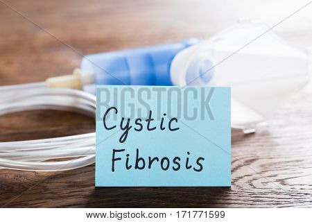 Cystic Fibrosis Concept With Inhaler Mask On Wooden Desk