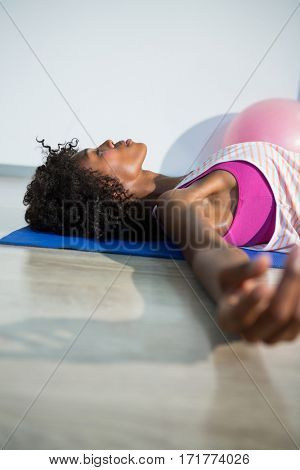 Woman in yoga corpse pose in gym