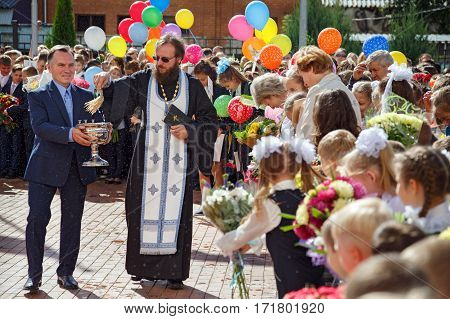 BALASHIKHA/ RUSSIA - SEPTEMBER 1. The priest sprinkles the crowd with holy water at the celebration of the beginning of the new school year on September 1, 2016 in city Balashikha, Moscow region, Russia.