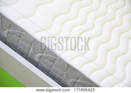 Textured mattress detail on a bed. Empty copy space for Editor's text.