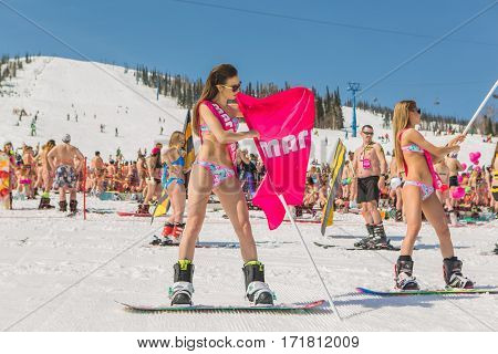 Group Of Young Happy Pretty Women On A Snowboard In Colorful Bikini With Flags.