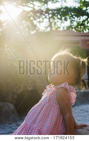 Beautiful Little Girl Is Sitting On A Rock The Sunset. Towers Ponagar. Vietnam.