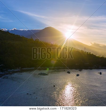 Sunrise over Gunung Agung volcano and Jemeluk Beach near Amed village, East of Bali, Indonesia.