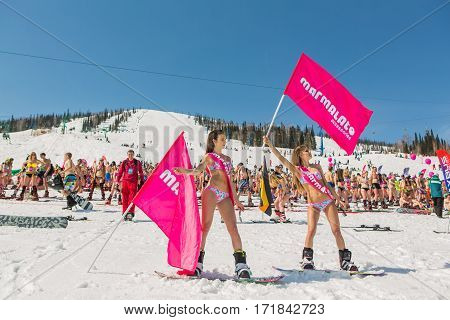 Group Of Young Happy Pretty Women On A Snowboard In Colorful Bikini With Flags.