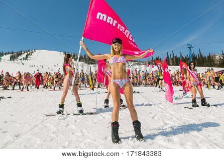 Group Of Young Happy Pretty Women On A Snowboard In Colorful Bikini With Flags.