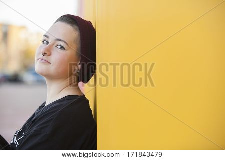 portrait of a teen gay woman on a yellow wall