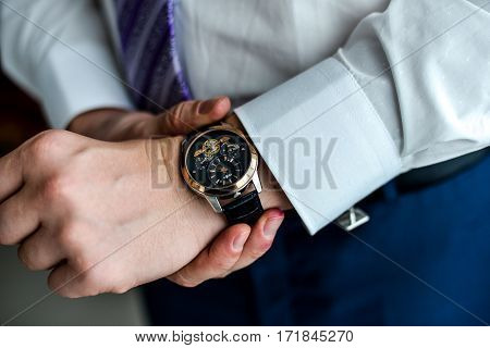 Close-up of a man in a tux fixing his cufflink. groom bow tie cufflinks