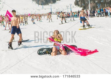 Group Of Young Happy Pretty Women On A Snowboard In Colorful Bikini With Flags.