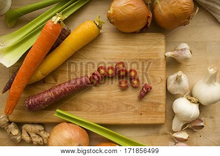 Sliced carrot surrounded by an assortment of fresh vegetables.