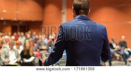 Speaker giving a talk on corporate Business Conference. Audience at the conference hall. Business and Entrepreneurship event.
