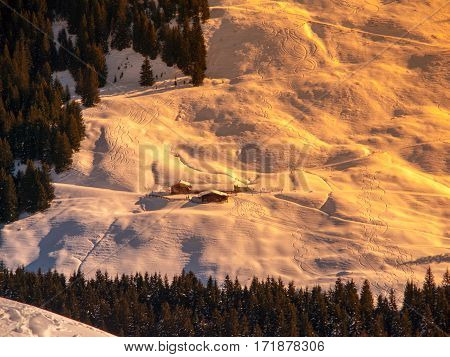 Evening view of alpine hut in the steep slope. Winter backountry ski touring area, Austrian Alps, Europe.