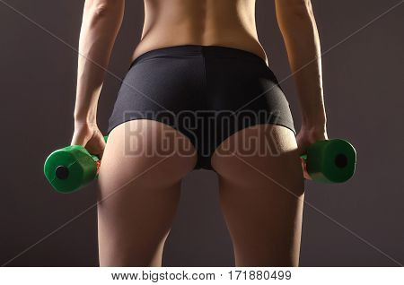 Women's Ass In Black Shorts On A Gray Background.