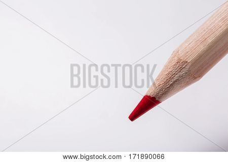 red pencil draws or writing on white paper sheet. Sharpen pencil. Education and school. Colorful pencil. Wooden. Office suppiels.