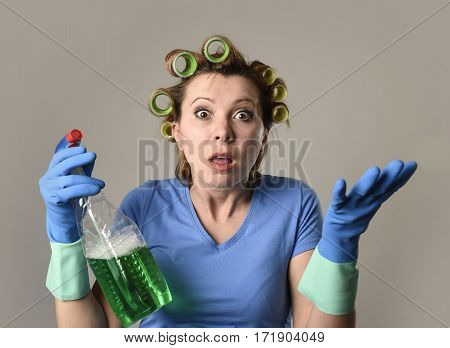 young overworked and frustrated service maid cleaning woman or lazy housewife in stress in hair rollers with washing spray bottle desperate angry and tired complaining in housework concept