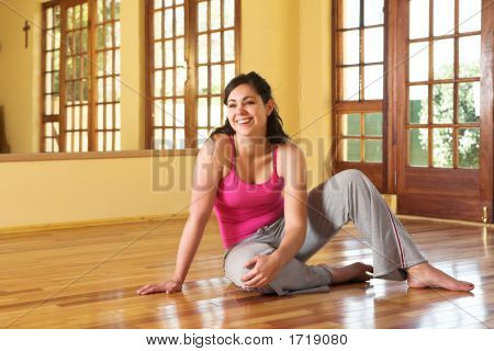 Mujer joven sana en traje de gimnasio sentados en el suelo